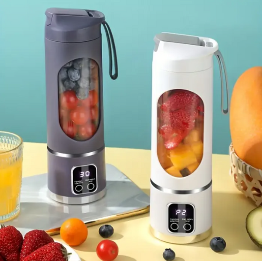 Two Rechargeable Portable Juicer with fruits inside on a table with a glass of juice and more fruits.