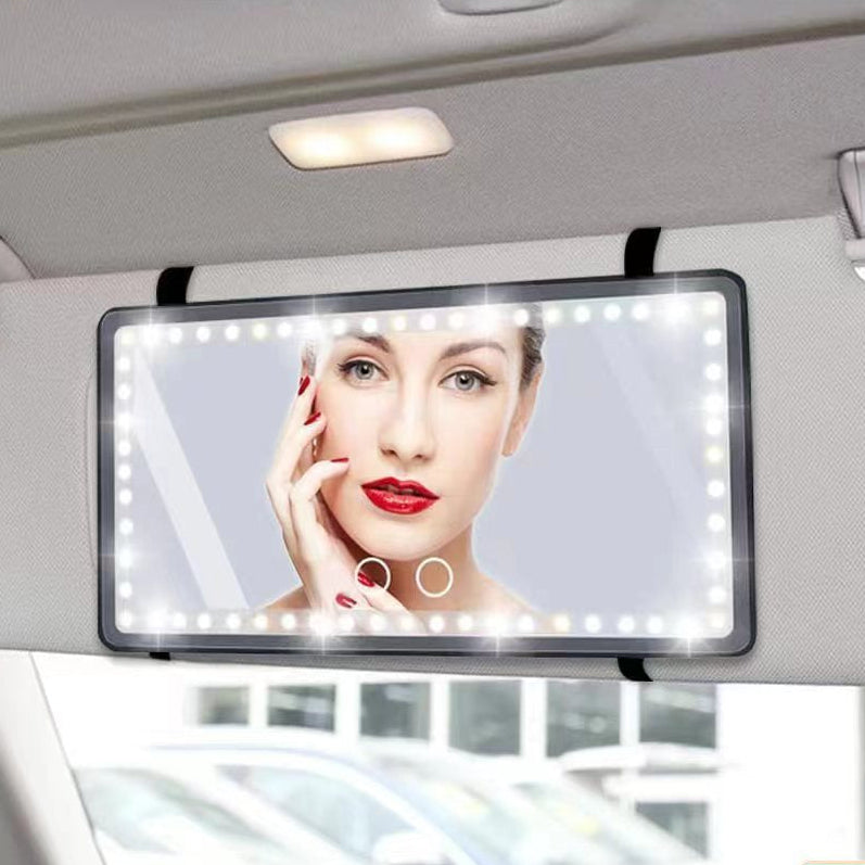 Car visor mirror with LED lights and a display of a woman's face, mounted on a car's sun visor.