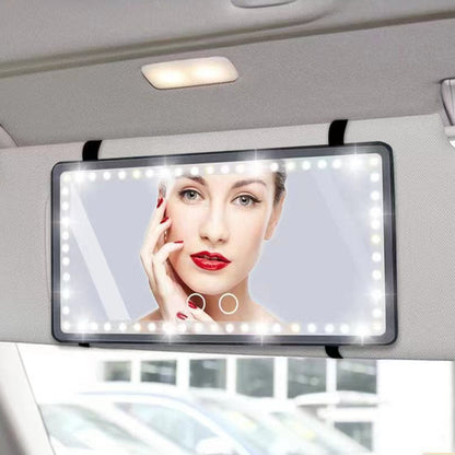 Car visor mirror with LED lights and a display of a woman's face, mounted on a car's sun visor.