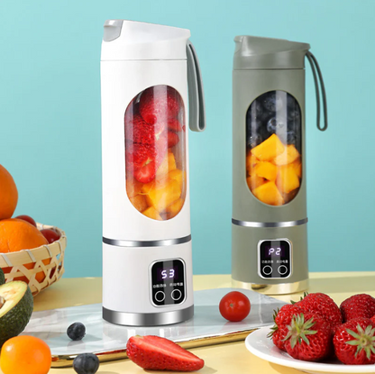 Two portable blenders with fruit inside on a table with fruits around